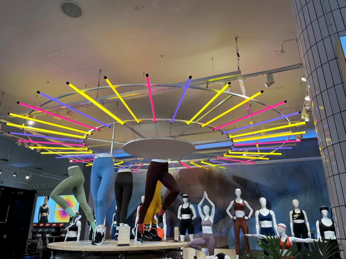 Circular ceiling luminaire at Nike Town fitted with vivid interchangeable coloured sleeves.