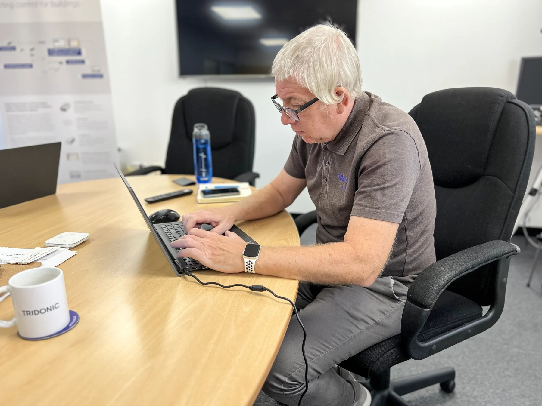 Tridonic Distribution UK team member reviewing lighting control documentation on a laptop